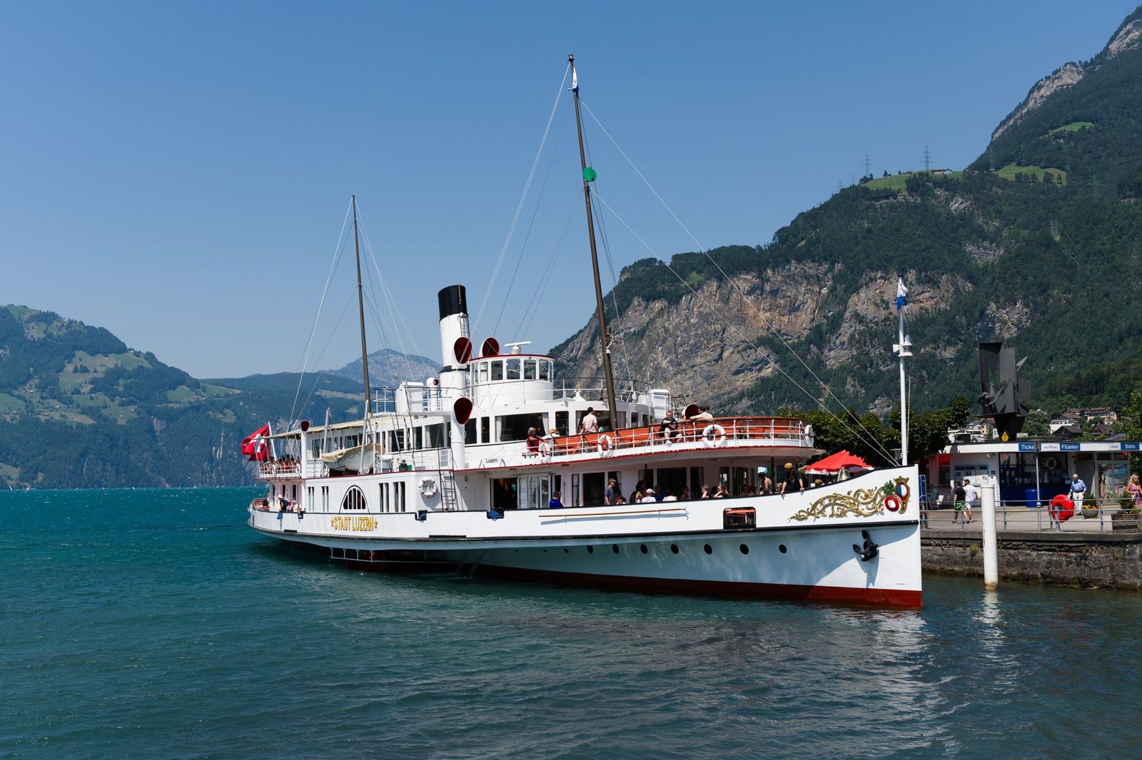 Paddle steamer with Swiss flag on a lake in front of mountains