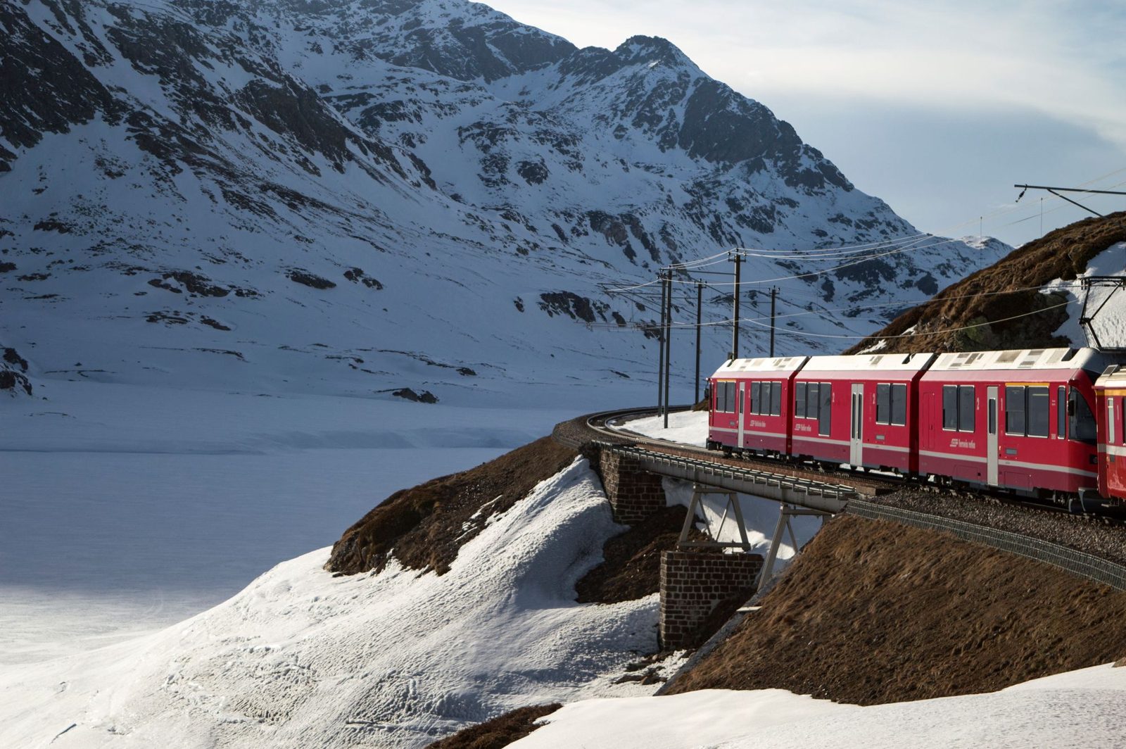 Red Bernina Express in a snowy mountain landscape